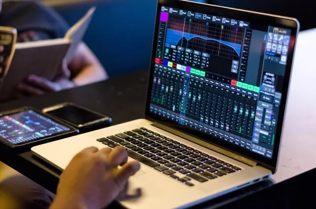 Behringer digital mixer app on a laptop: channel faders and an equalizer curve