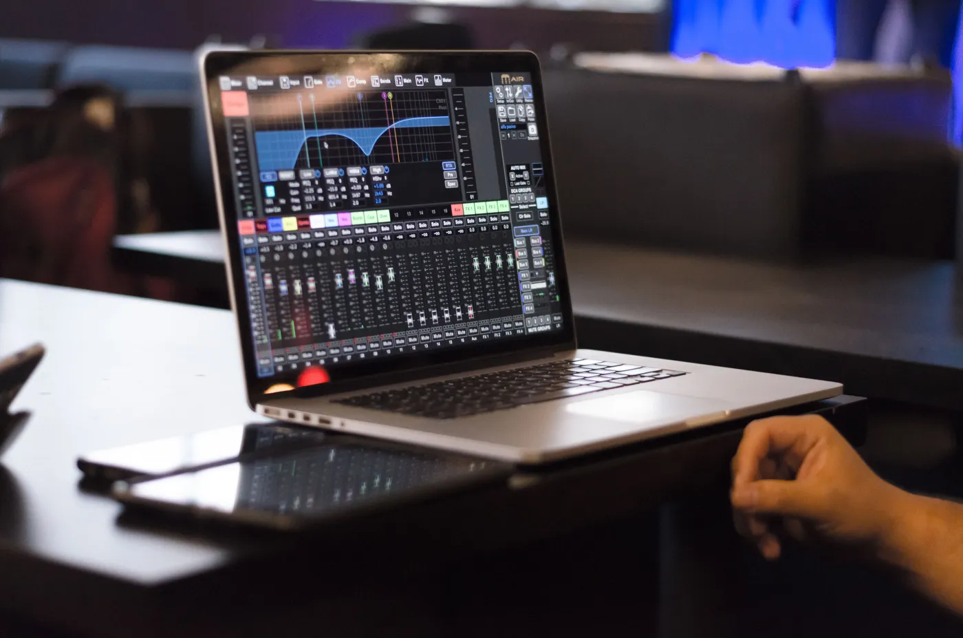 A digital mixer control app on a laptop, with a tablet and a phone next to it