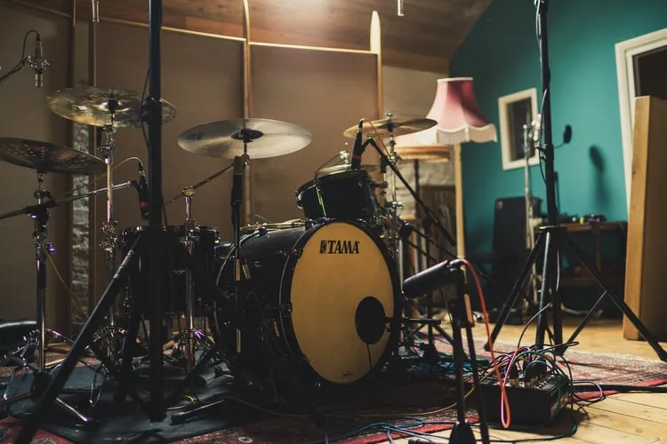 Comparison photo: Tama drum kit with mics in a messy room, cables and stuff in the background