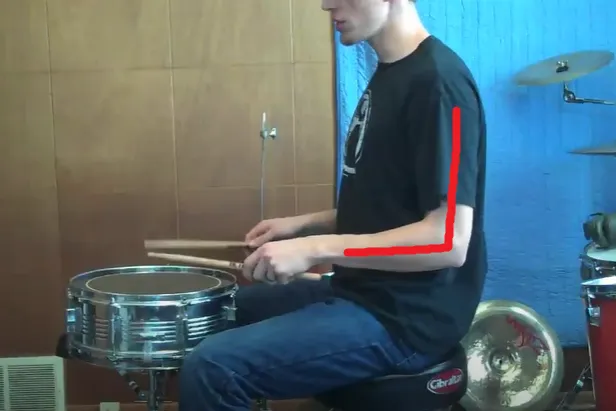 Snare height: a red line shows the right angle between the forearm and upper arm while playing