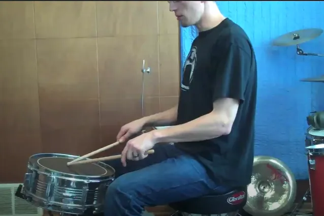 Snare too far from the lap, the drummer reaches forward with the sticks