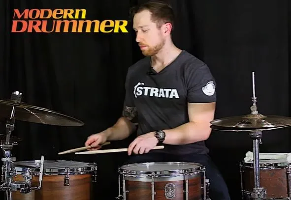 Drummer playing the snare, floor tom on the right at the same height as the snare