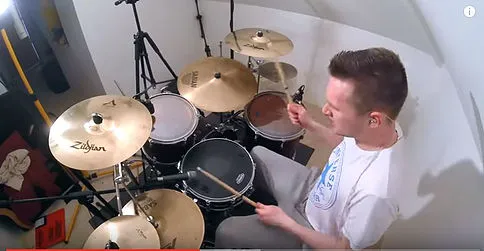 Drummer playing a kit with Zildjian cymbals and a crash set almost flat
