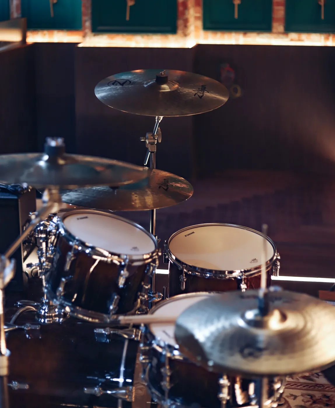 Acoustic drum kit: toms, snare and cymbals in moody lighting