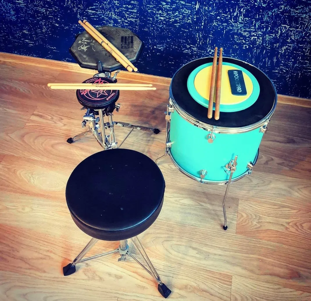 Practice gear: practice pads on stands, a muffled tom and a drum throne