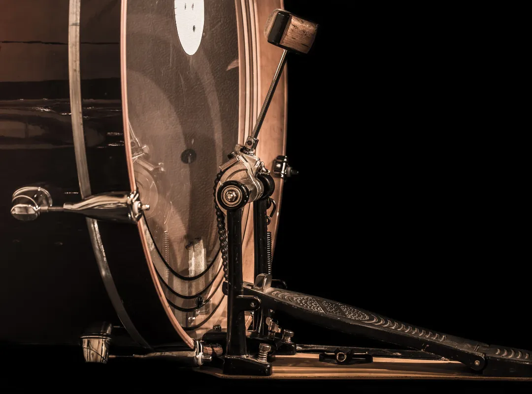 Bass drum pedal attached to the bass drum hoop, beater against the head