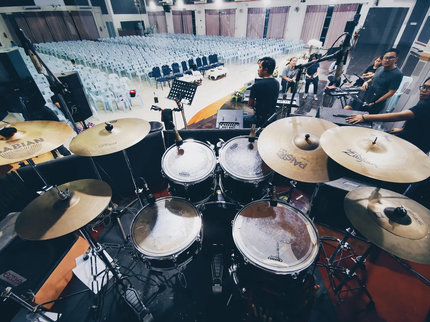 A drum kit with Sabian and Zildjian cymbals on stage, seen from the drummer's point of view