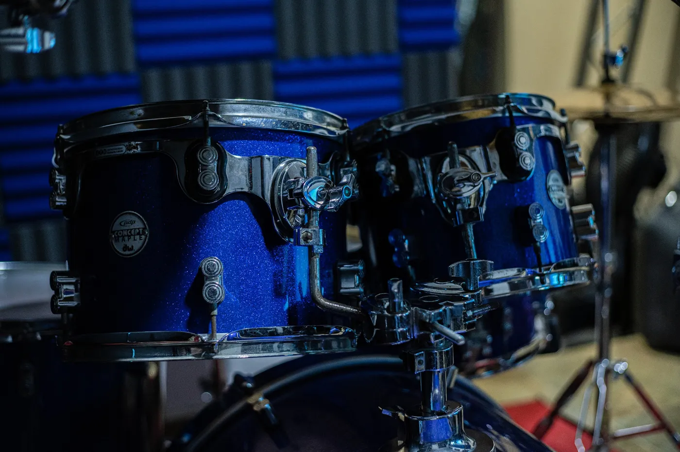 Two blue rack toms attached to a tom holder on top of the bass drum