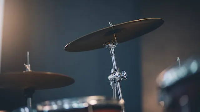 A ride cymbal on a straight cymbal stand in a studio