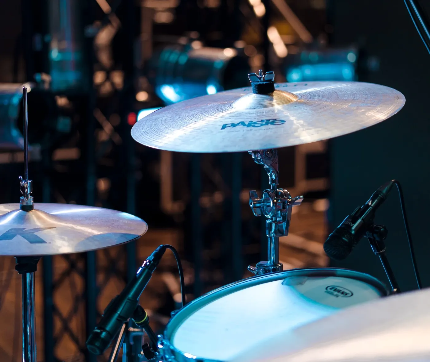 A Paiste cymbal on a stand on stage, with a miked tom underneath