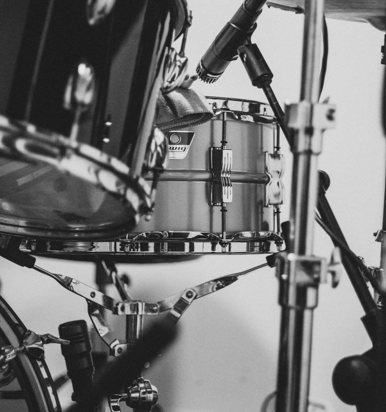 A metal-shell snare on a snare stand under a microphone