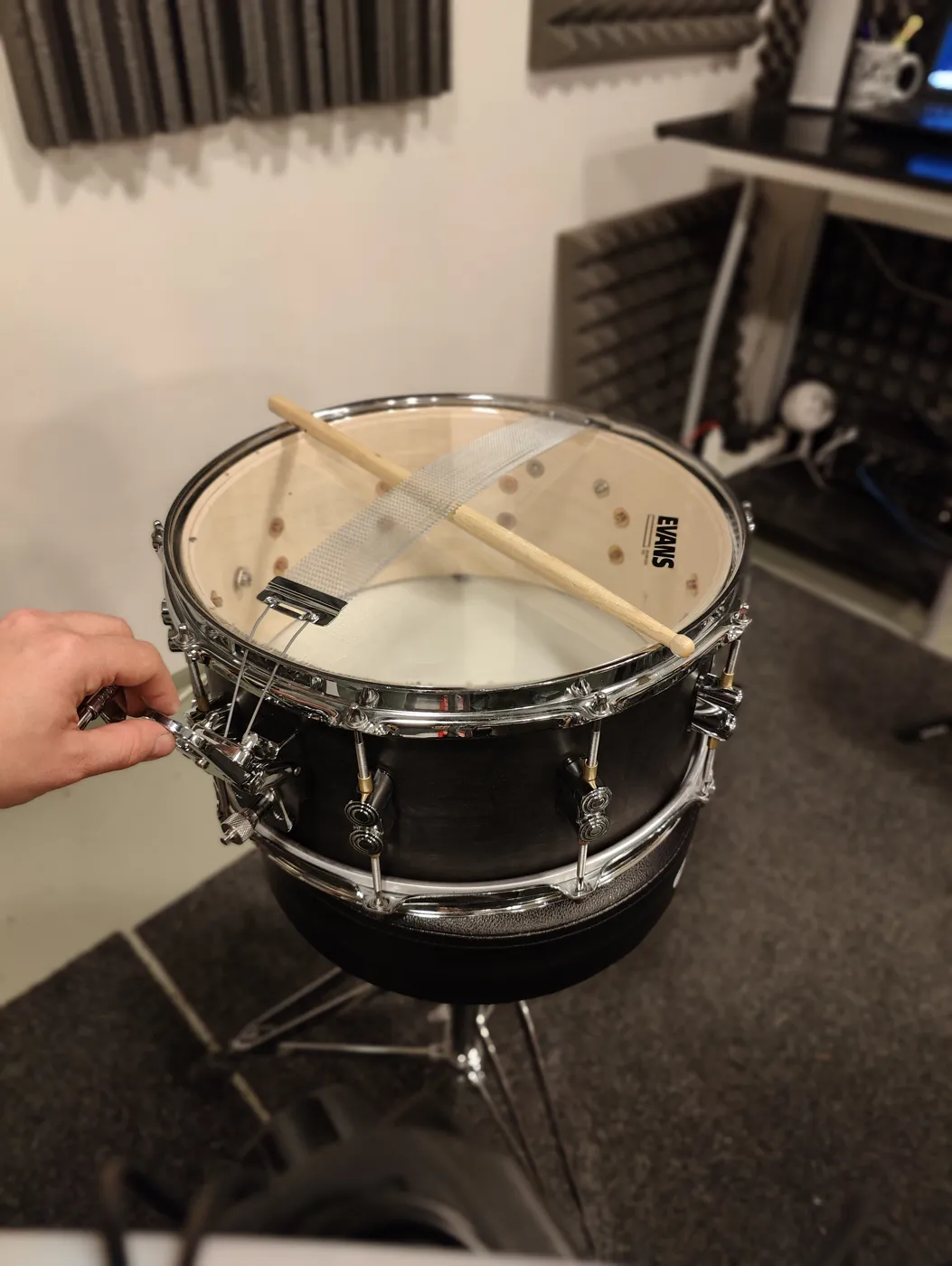 Tuning the snare's resonant head with a stick between the wires and the head so the wires don't touch the head