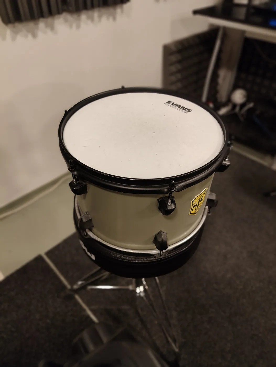 The tom to be tuned, removed from its stand and placed on a drum throne