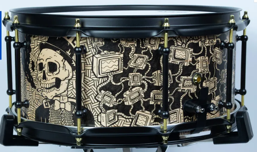 An artistically illustrated snare with a skull and a machine-themed drawing