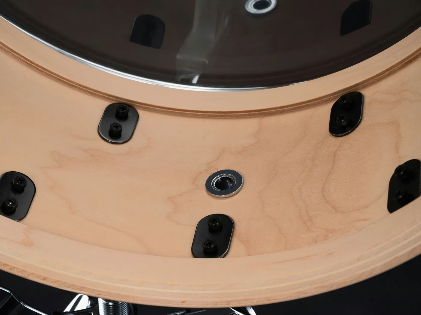 Close-up of the wood surface and hardware of a maple-shell snare from inside the shell